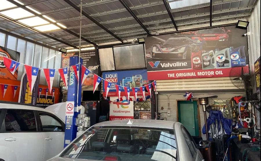 Interior del taller SalasMotors, con elevador y autos en atención