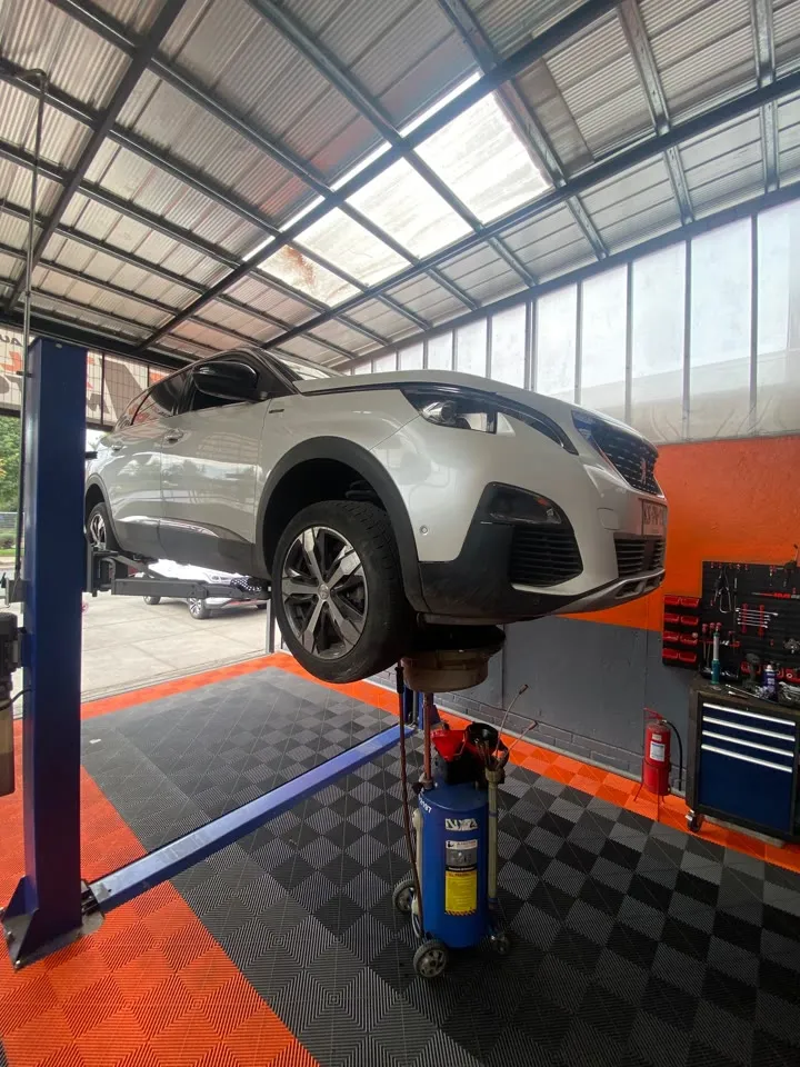 Peugeot 3008 plateado levantado en un elevador